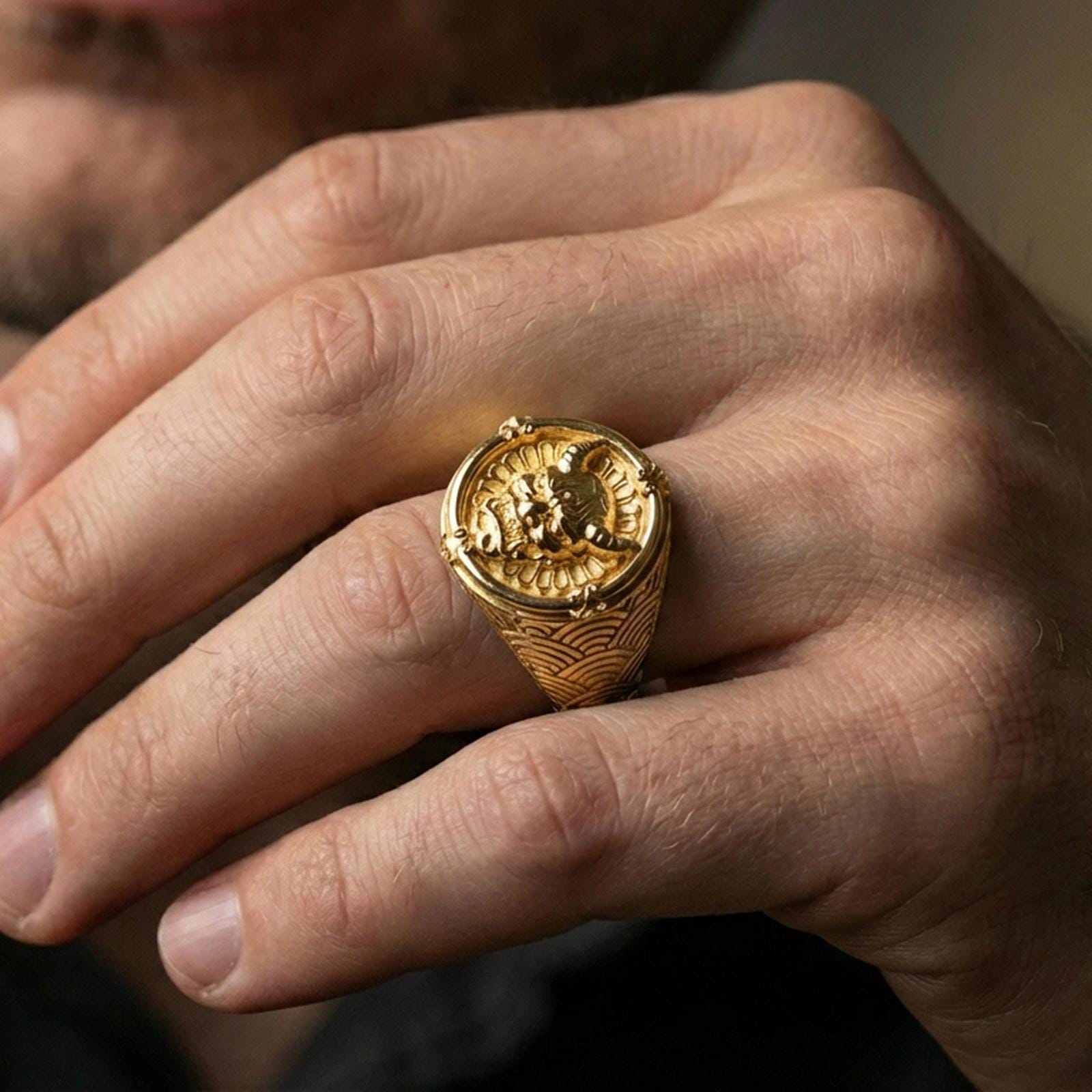 Gold plated oni mask statement ring with seigaiha wave shoulders worn on a finger, close-up lifestyle photo focusing on the relief and texture