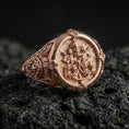 Load image into Gallery viewer, Rose gold plated Saint Peter signet ring with Keys of Heaven motif and papal tiara relief, close-up on black volcanic stone
