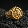 Load image into Gallery viewer, Gold plated Saint Peter ring featuring Keys of Heaven and papal tiara engraving on a signet face, macro on dark volcanic rock
