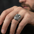 Load image into Gallery viewer, Oxidized finish knight signet ring worn on a finger, shield face with armored warrior and sword shown in a close-up lifestyle shot
