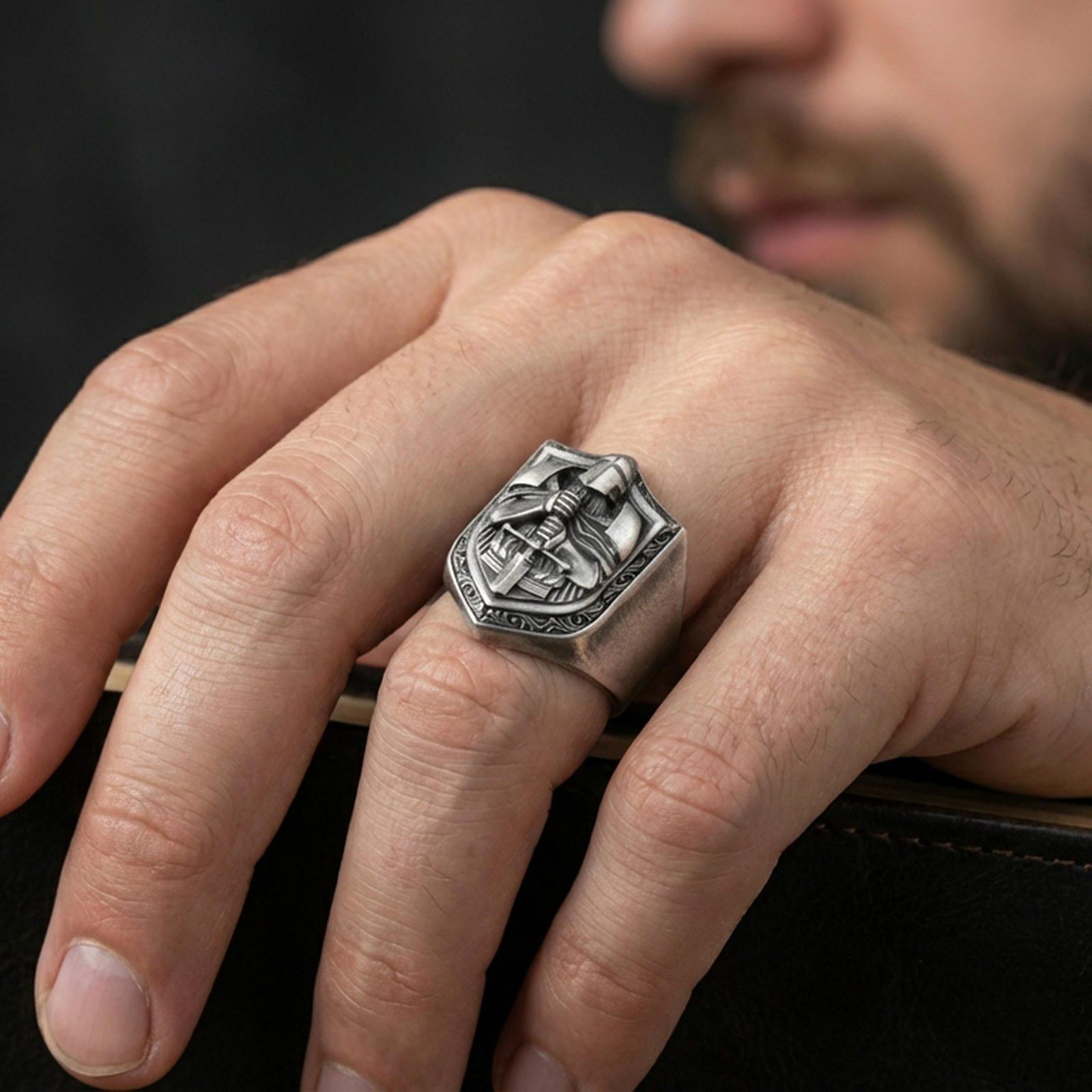 Oxidized finish knight signet ring worn on a finger, shield face with armored warrior and sword shown in a close-up lifestyle shot