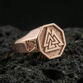 Load image into Gallery viewer, Sterling silver Valknut signet ring with a rose gold plated finish, octagonal signet face with the Norse Valknut symbol and side engraving, close-up on volcanic rock
