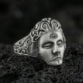 Load image into Gallery viewer, Sterling silver third eye face ring with an oxidized finish, sculpted calm mask and engraved swirling band details, macro on black volcanic rock
