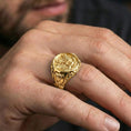 Load image into Gallery viewer, Gold plated finish US eagle seal signet ring worn on a finger, close-up lifestyle photo focusing on the raised emblem and statement look
