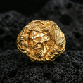 Load image into Gallery viewer, Sterling silver skull ring with a gold plated finish, bold gothic skull centerpiece with eagle wings and talon accents, macro on volcanic rock
