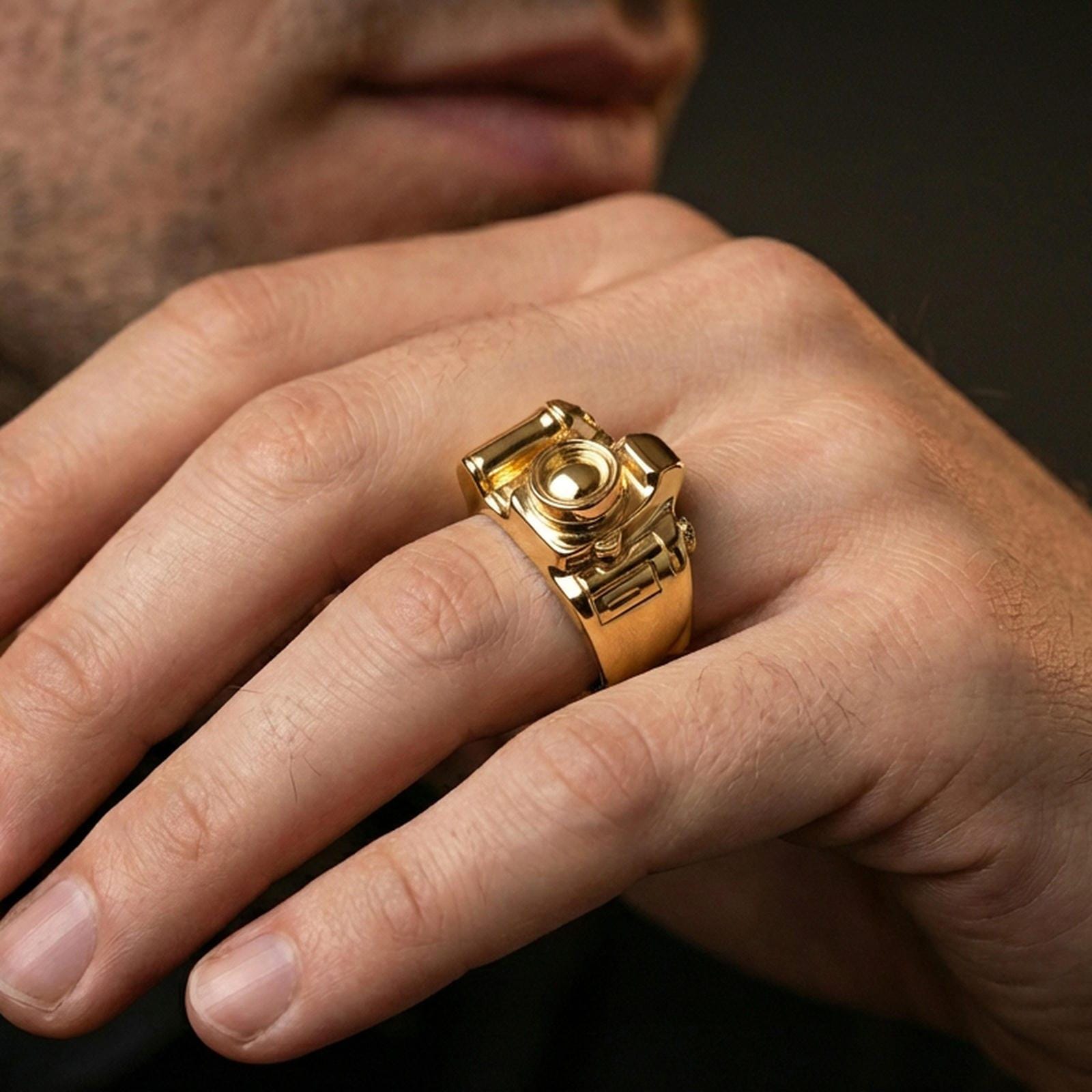 Gold plated finish sterling silver camera signet ring worn on a finger, close-up lifestyle photo emphasizing the camera lens relief and sculpted edges
