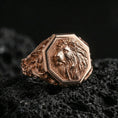 Load image into Gallery viewer, Rose gold plated lion signet ring on volcanic rock, octagonal lion signet with ornate scrollwork shoulders and high-detail mane relief, luxury product shot
