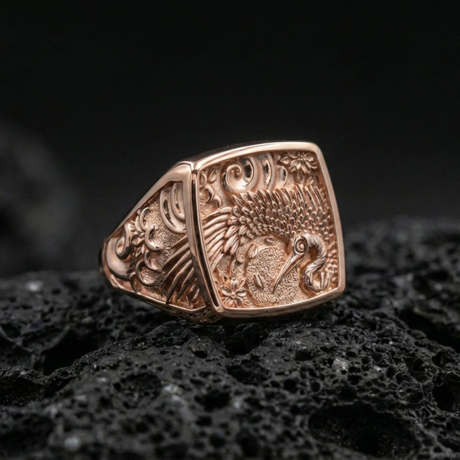925 sterling silver crane signet ring on volcanic stone, rose gold plated finish with warm tone enhancing the crane, feathers, and decorative pattern