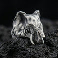 Load image into Gallery viewer, Oxidized sterling silver elephant ring on textured volcanic rock, close-up studio shot with premium dark background
