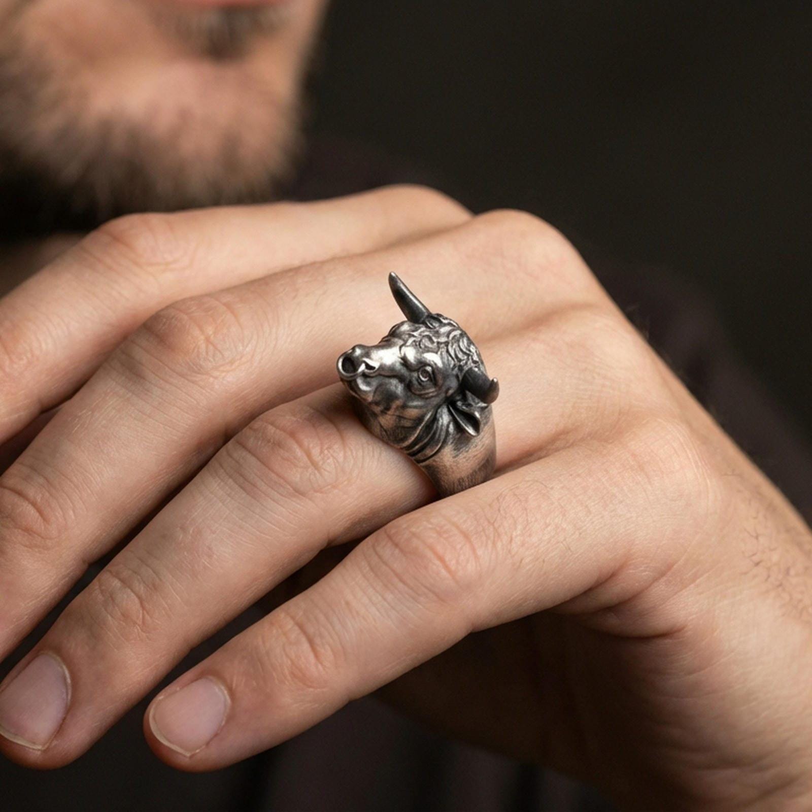 Oxidized bull head ring worn on finger, lifestyle close-up focusing on horns and nose ring detail for a bold statement look