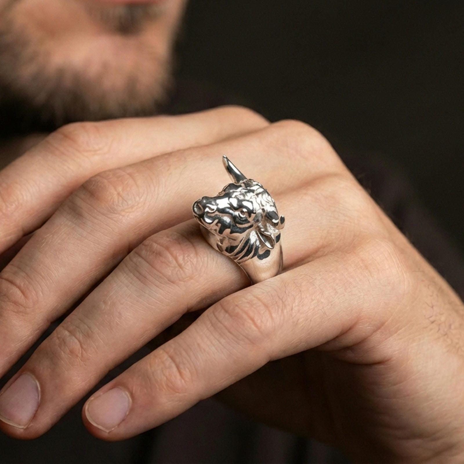 Polished silver bull ring on finger, natural hand pose highlighting the realistic animal head sculpt and solid band shape
