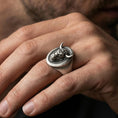Load image into Gallery viewer, Oxidized bull signet ring worn on finger, lifestyle close-up focusing on the oval face and front-facing horned head relief
