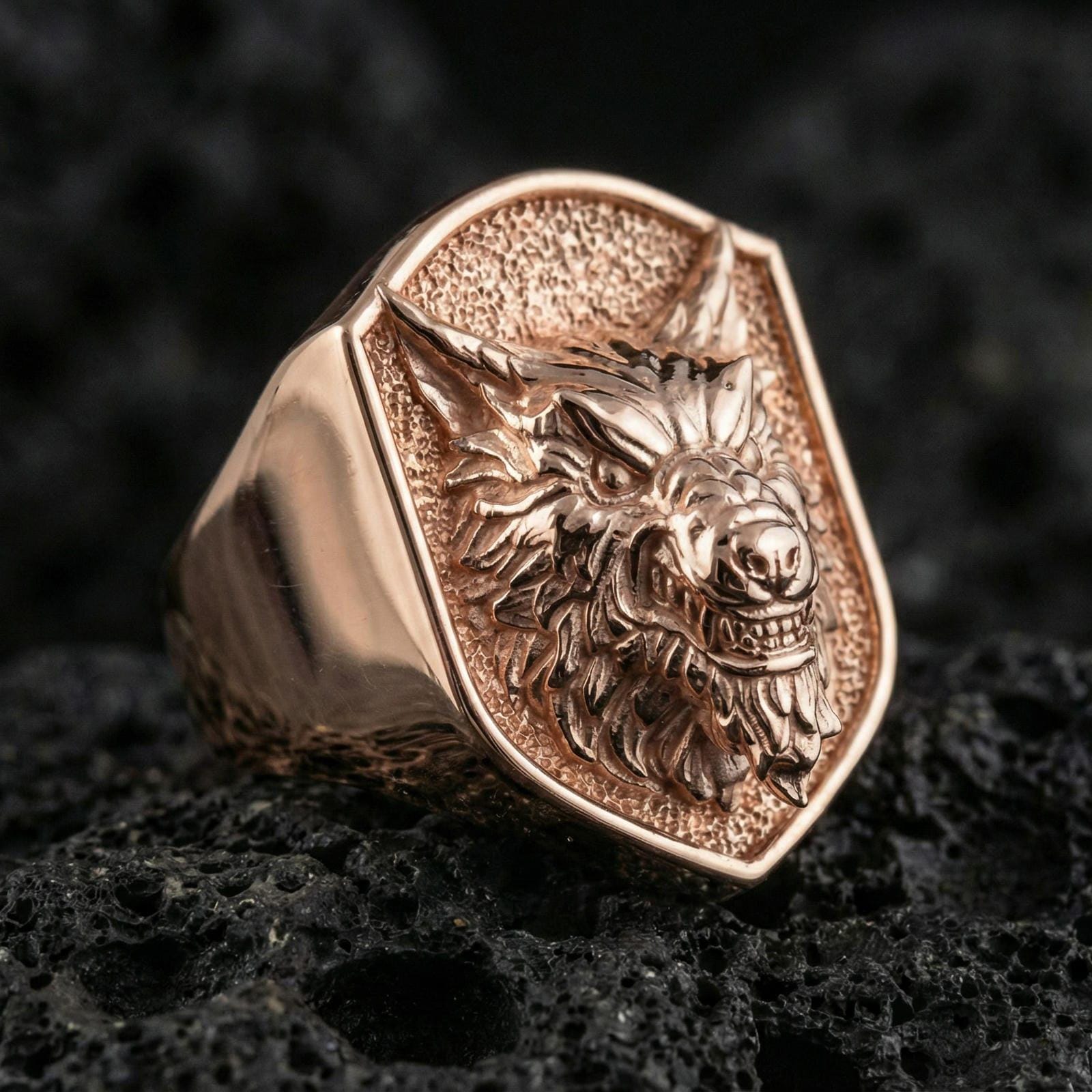 Rose gold plated angry wolf ring on volcanic rock, aggressive wolf face signet ring detail