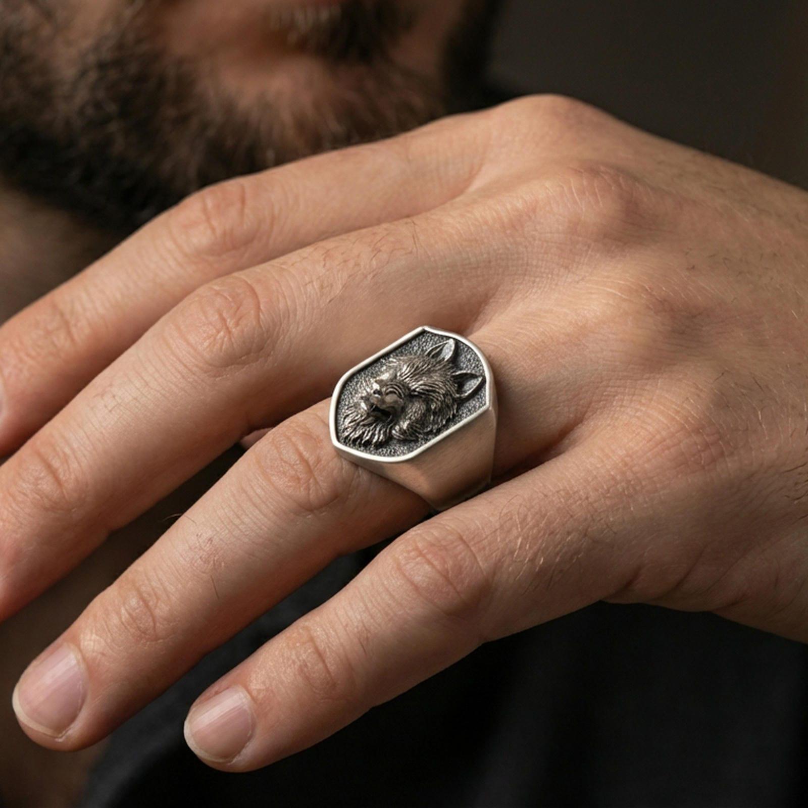 Oxidized matte wolf ring worn on finger, masculine signet style with bold wolf head