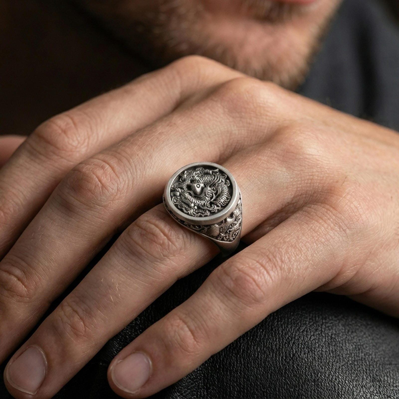 Oxidized koi fish signet ring worn on finger, lifestyle close-up focusing on the round face and detailed fish scale engraving