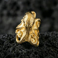 Load image into Gallery viewer, Gold plated octopus ring on porous volcanic stone, premium dark studio shot emphasizing detailed tentacle suction cups and bold nautical design

