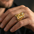 Load image into Gallery viewer, Gold plated octopus ring worn on finger, lifestyle wear shot emphasizing the nautical octopus design and sculpted suction cup details
