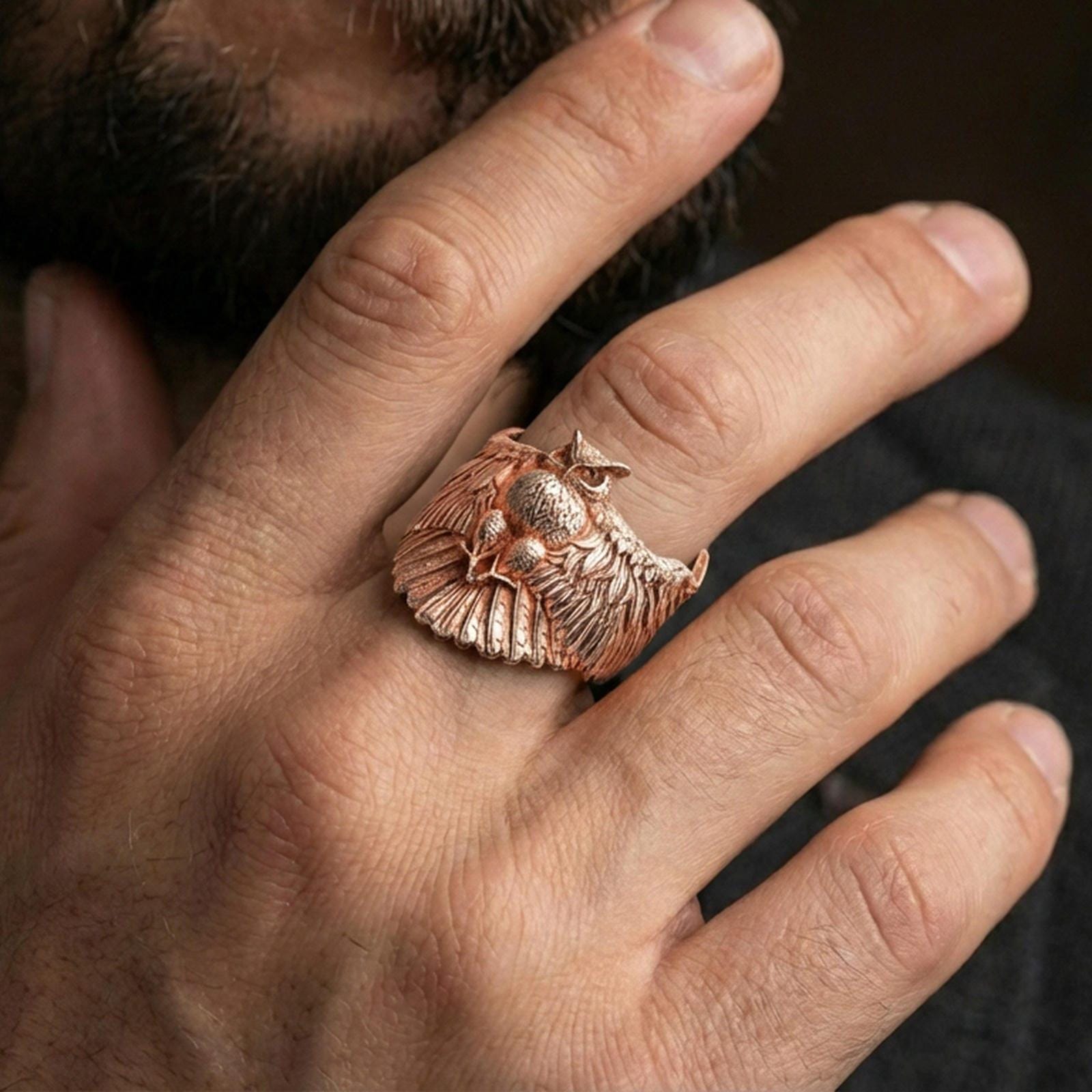 Rose gold plated owl ring on finger, close-up lifestyle photo showcasing the owl wingspan, feather texture, and statement look