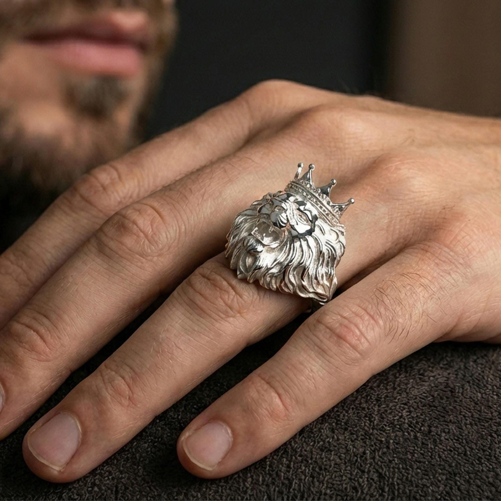 Polished silver lion king ring on finger, natural hand pose highlighting the regal crown, sculpted fangs, and bold statement silhouette