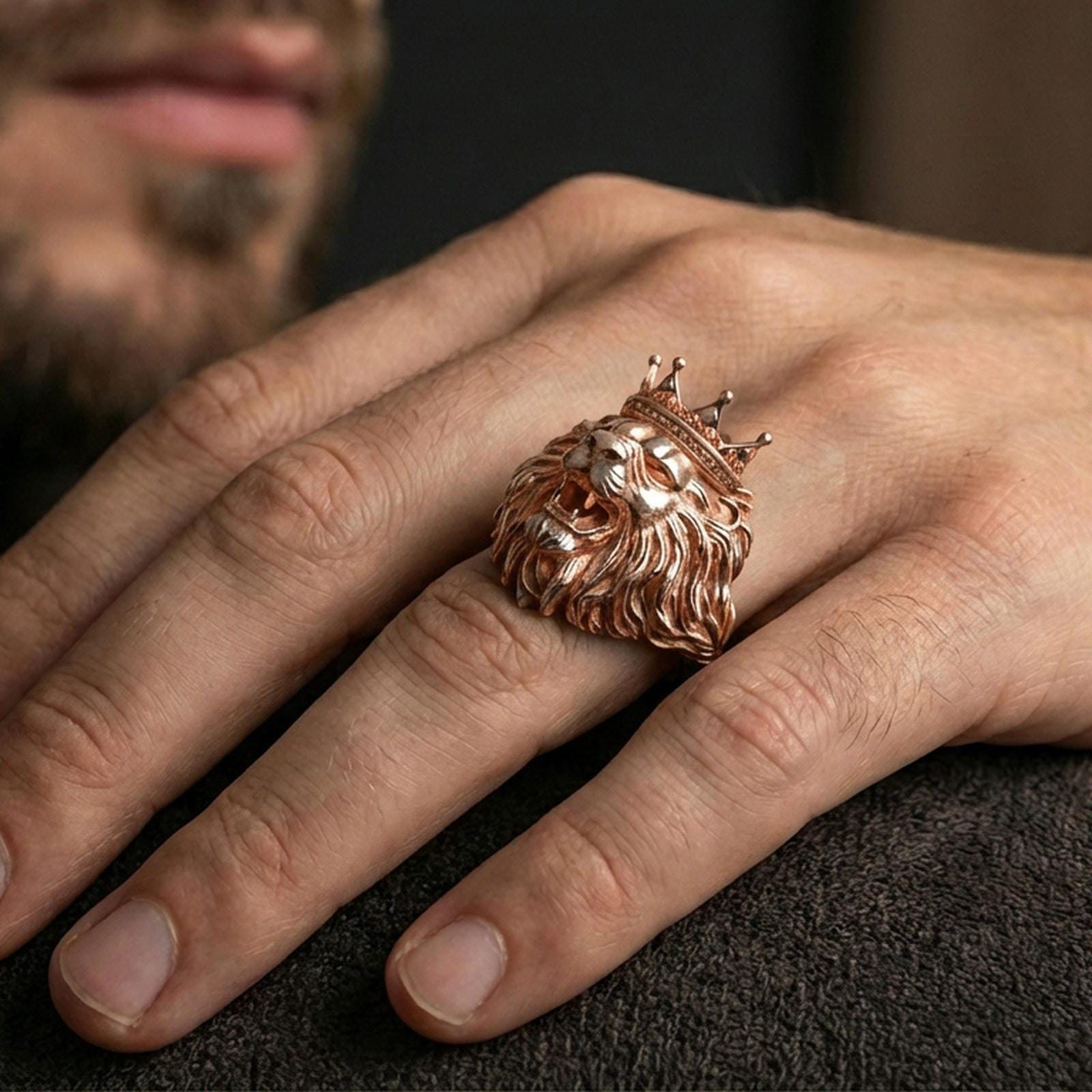 Rose gold plated lion head ring on finger, close-up lifestyle photo showcasing the crown, roaring expression, and detailed mane engraving