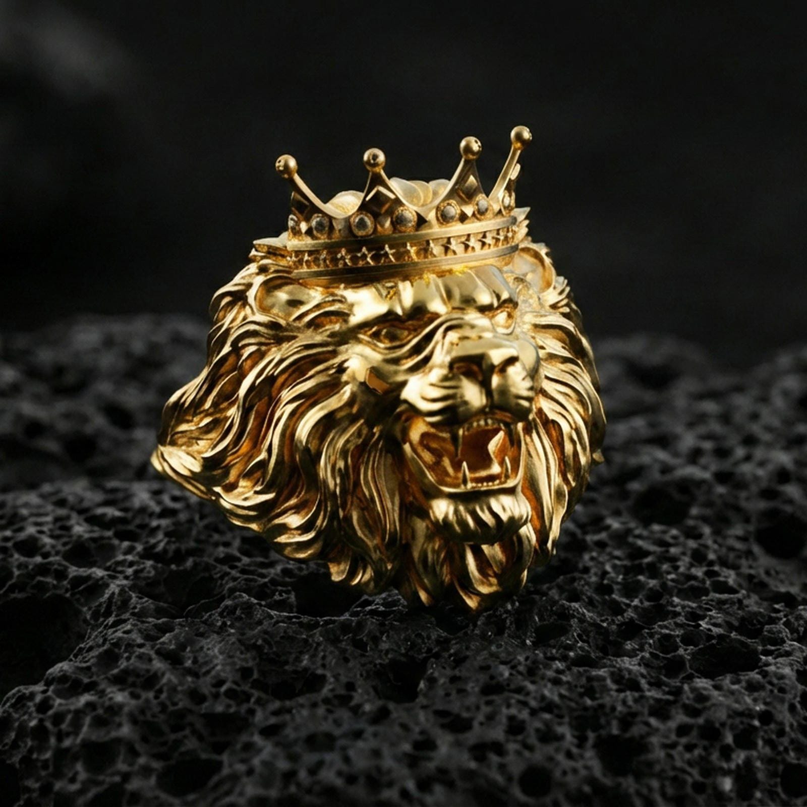 Gold plated crowned lion ring on porous volcanic stone, premium dark studio shot emphasizing the regal crown, open mouth fangs, and bold mane relief