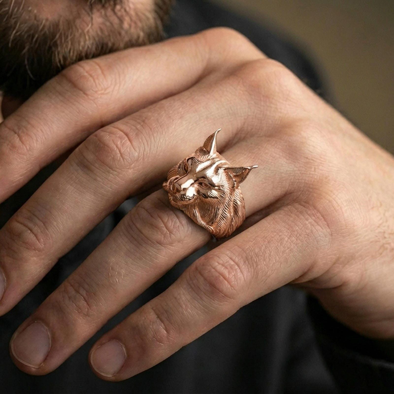 Rose gold plated lynx head ring on finger, close-up lifestyle photo showcasing the feline profile, detailed fur pattern, and statement look