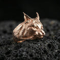 Load image into Gallery viewer, Rose gold plated lynx head ring on volcanic rock, sharp macro product photo showcasing the realistic feline profile and detailed fur pattern
