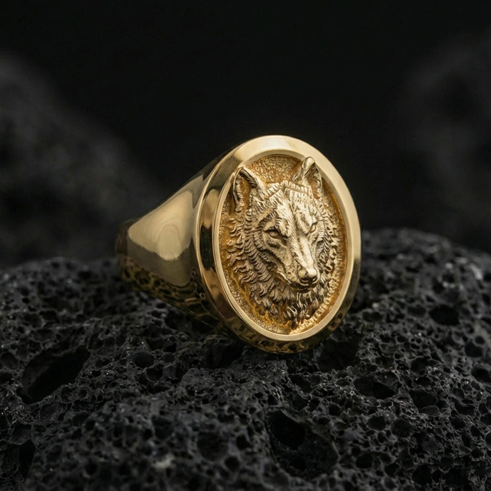 Gold plated wolf head signet ring on volcanic stone, bold animal face with clean bezel edge