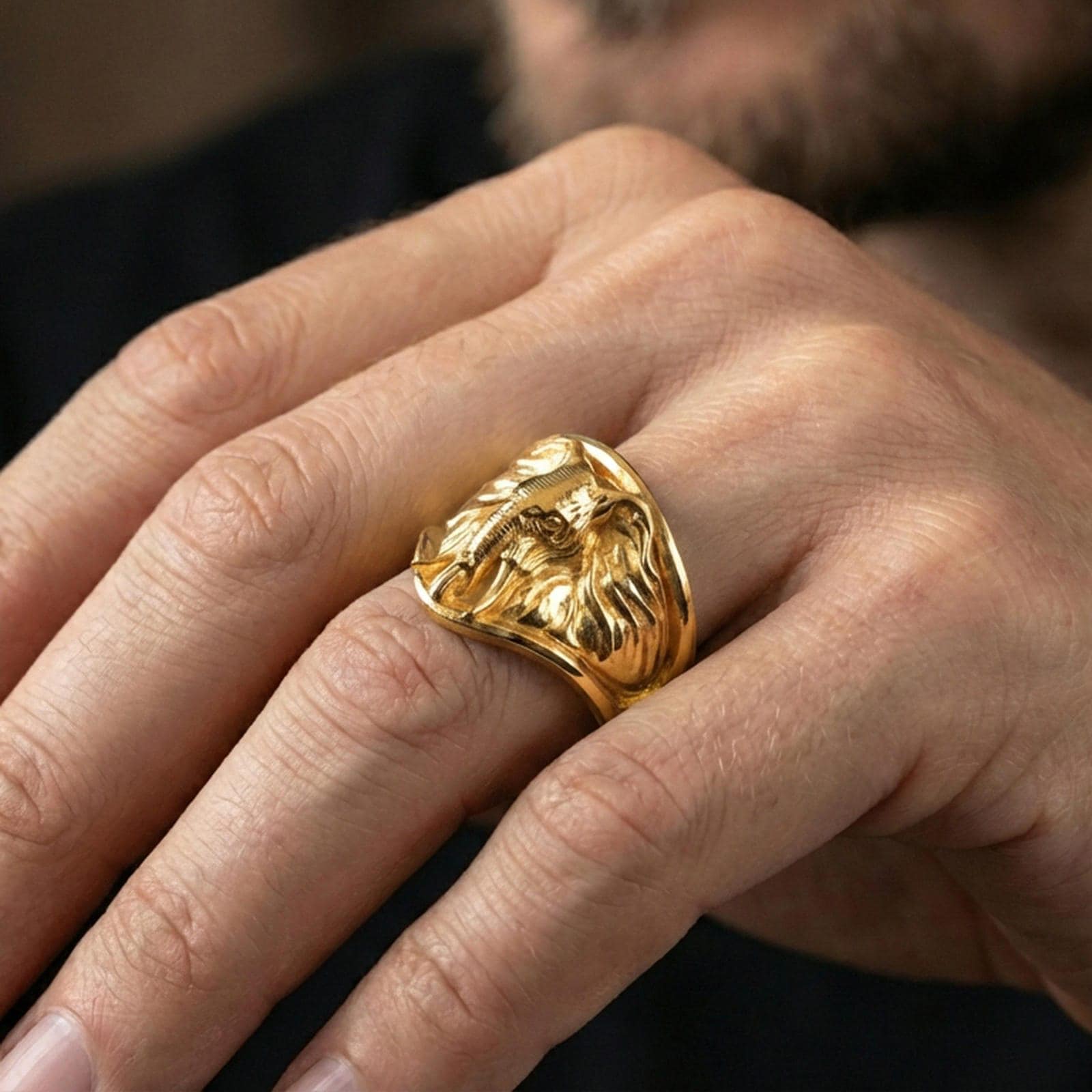 Gold plated elephant signet ring worn on finger, lifestyle wear shot emphasizing the safari elephant portrait and strong statement look