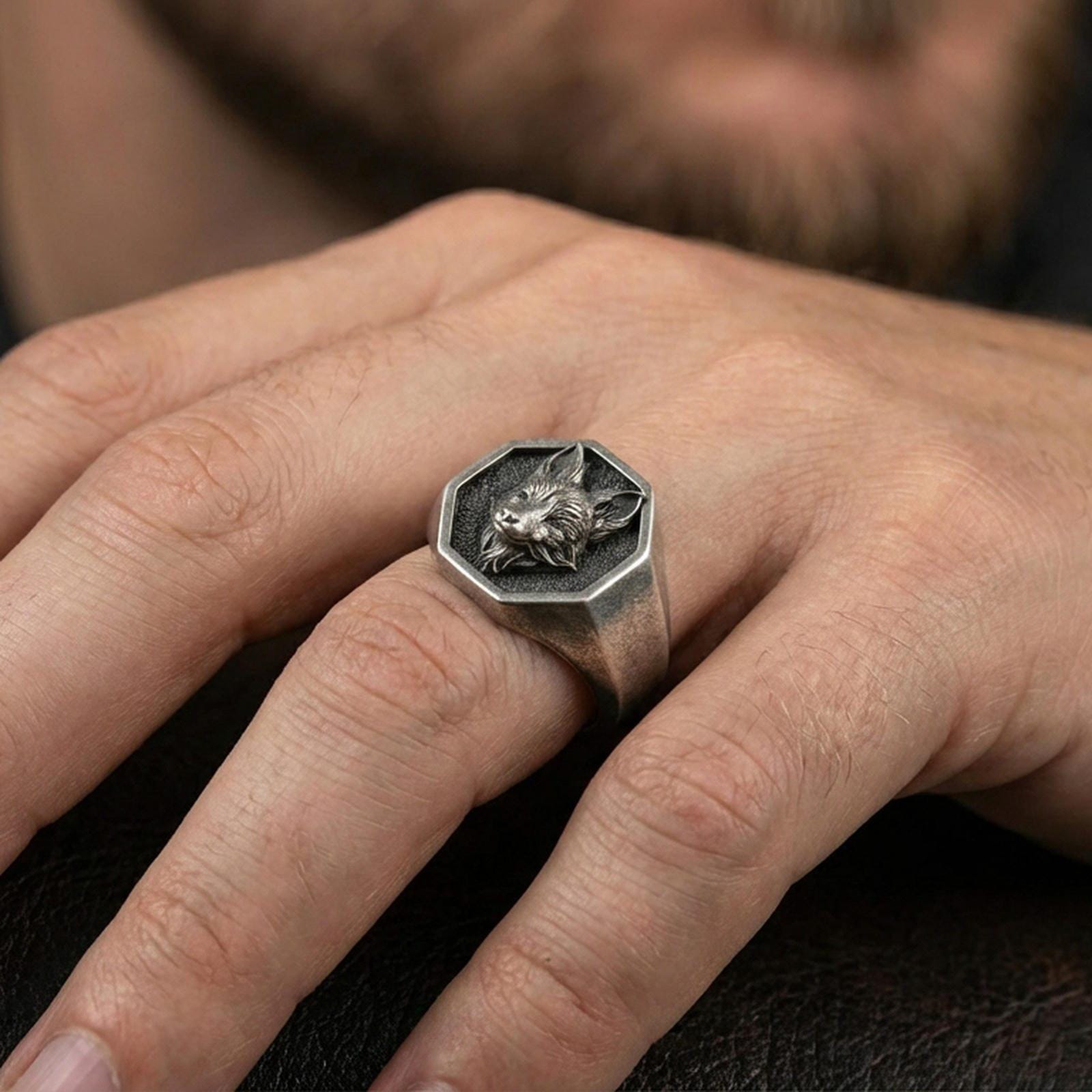 Oxidized sterling silver fox signet ring worn on a finger, showing the octagon face and engraved fox detail