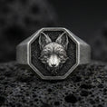 Load image into Gallery viewer, Close-up of an oxidized sterling silver fox signet ring centered on porous volcanic rock in a dark studio setting
