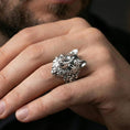 Load image into Gallery viewer, Polished silver wolf head ring on a hand, close-up view highlighting the calm expression and raised carving
