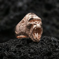 Load image into Gallery viewer, Rose gold plated gorilla ring displayed on rugged volcanic rock with dramatic shadows and high detail
