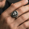 Load image into Gallery viewer, Oxidized leopard signet ring worn on finger, lifestyle close-up focusing on the round face and raised big cat portrait with textured background

