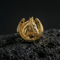 Load image into Gallery viewer, Gold plated horseshoe ring with horse head motif on porous volcanic stone, premium dark studio shot emphasizing the equestrian silhouette and sculpted details
