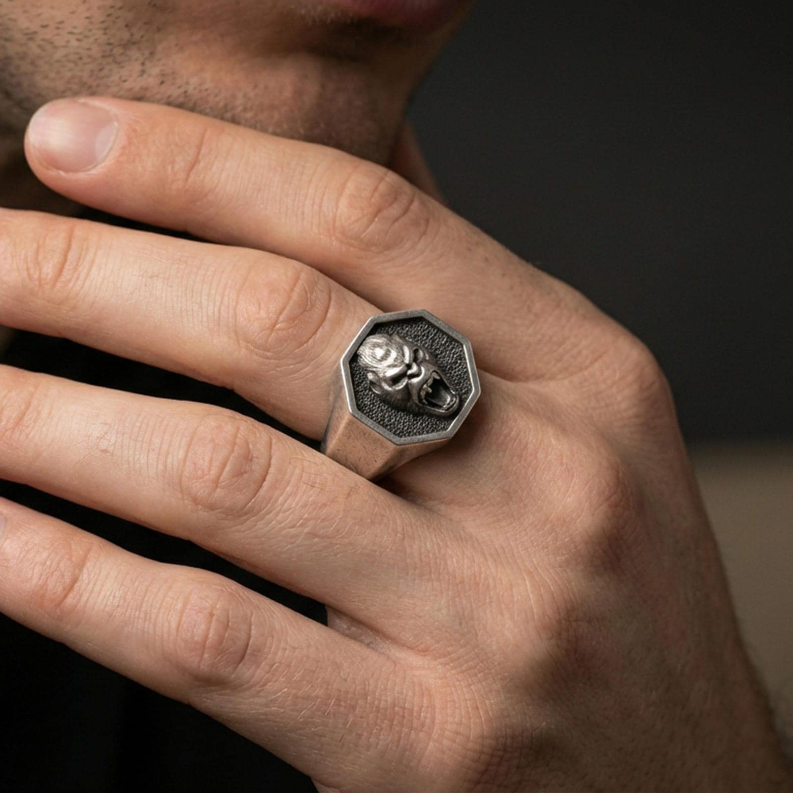 Oxidized sterling silver gorilla ring worn on a finger, showing the octagon face and roaring ape head design