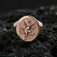 Load image into Gallery viewer, Rose gold plated royal lion signet ring on textured volcanic rock, luxury macro photo showcasing the lion crest relief and refined bezel finish
