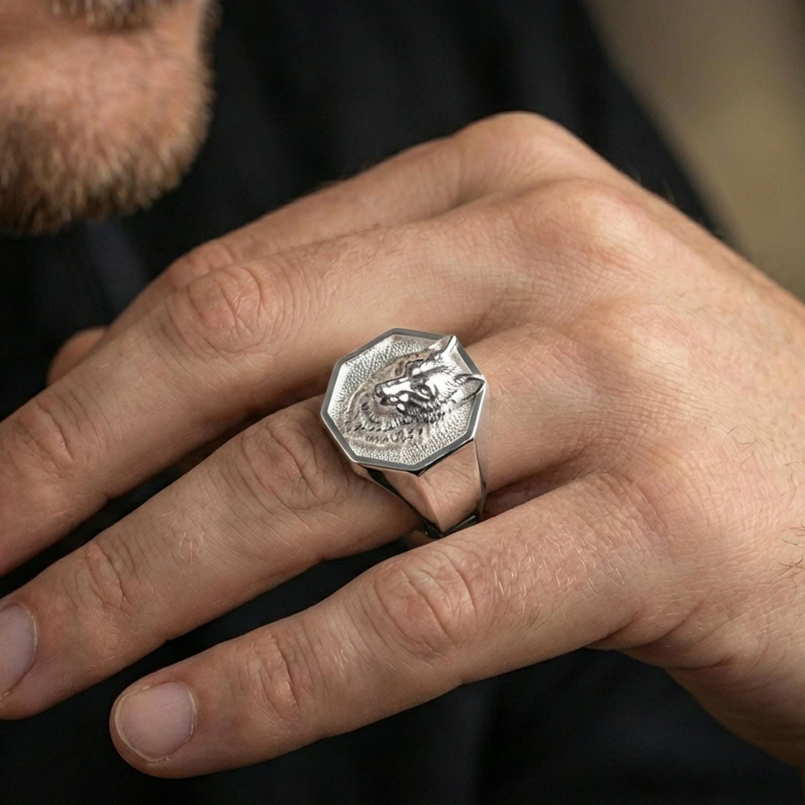 Polished silver wolf signet ring on a hand, close-up highlighting the crisp octagon frame and engraving depth
