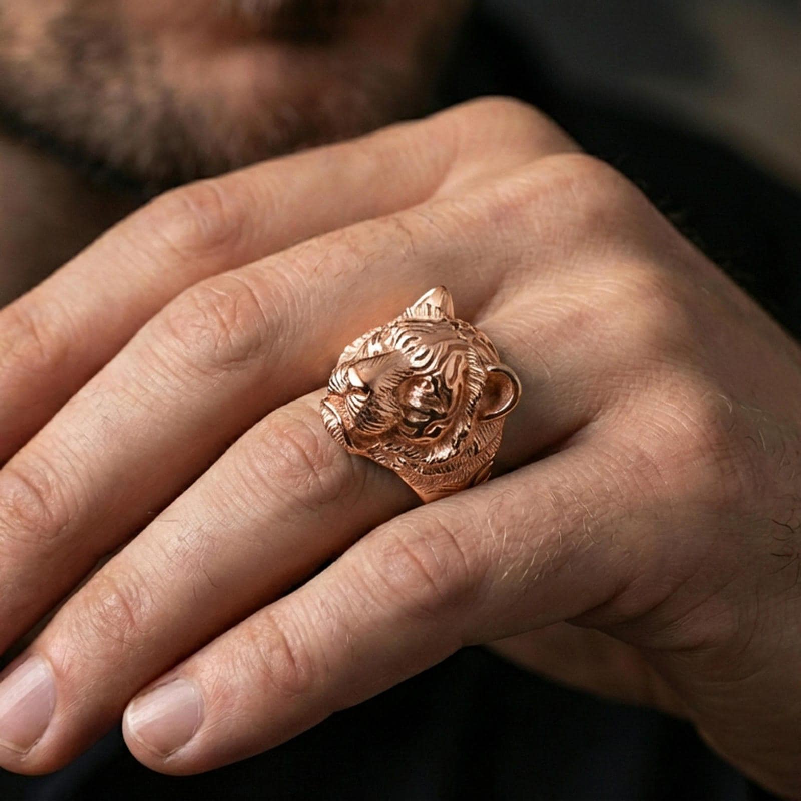 Rose gold plated tiger head ring worn on a finger, macro view focusing on facial details and texture