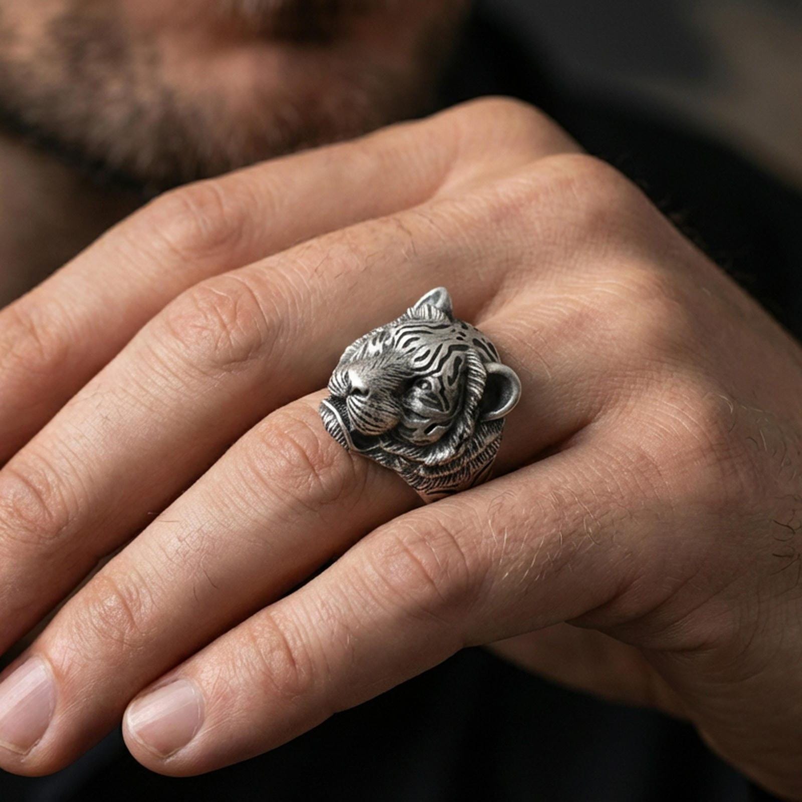 Oxidized sterling silver tiger ring worn on a finger, front view showing the detailed tiger face