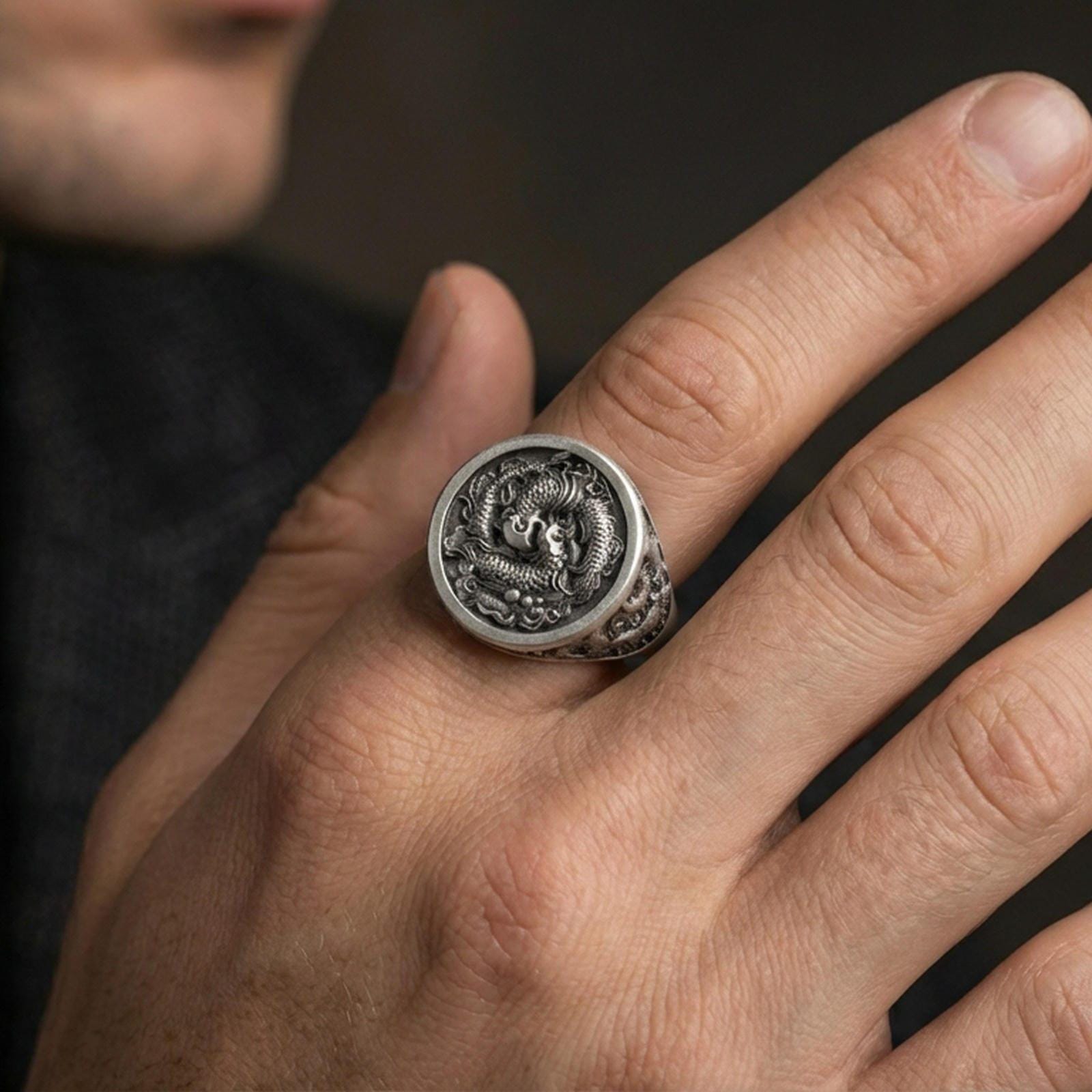 Oxidized sterling silver koi signet ring worn on a finger, angled view showing the yin yang koi motif