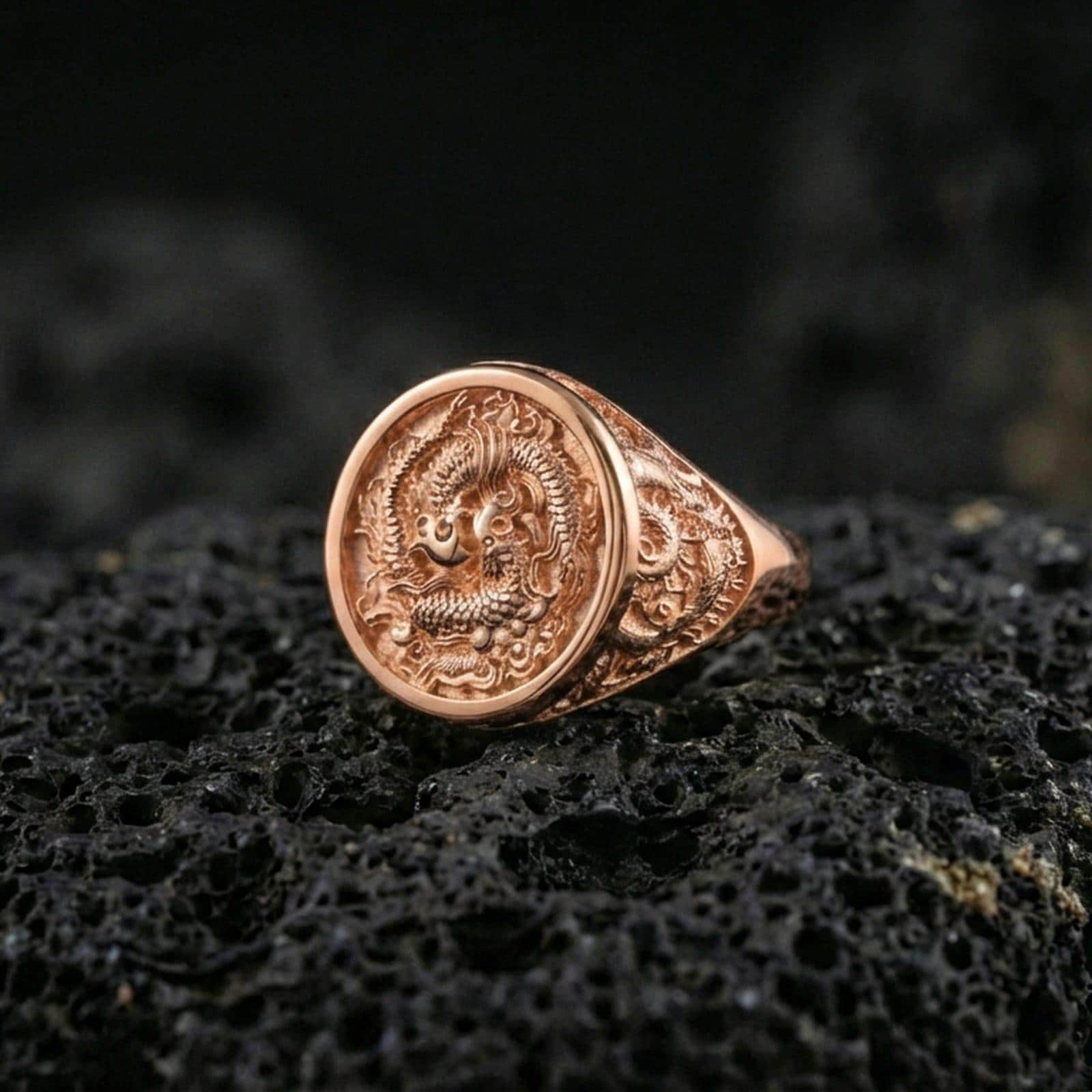 Rose gold plated koi fish harmony ring on porous volcanic rock with soft directional lighting