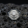 Load image into Gallery viewer, Polished silver geometric lion ring on textured volcanic stone, macro focus on the lion face engraving
