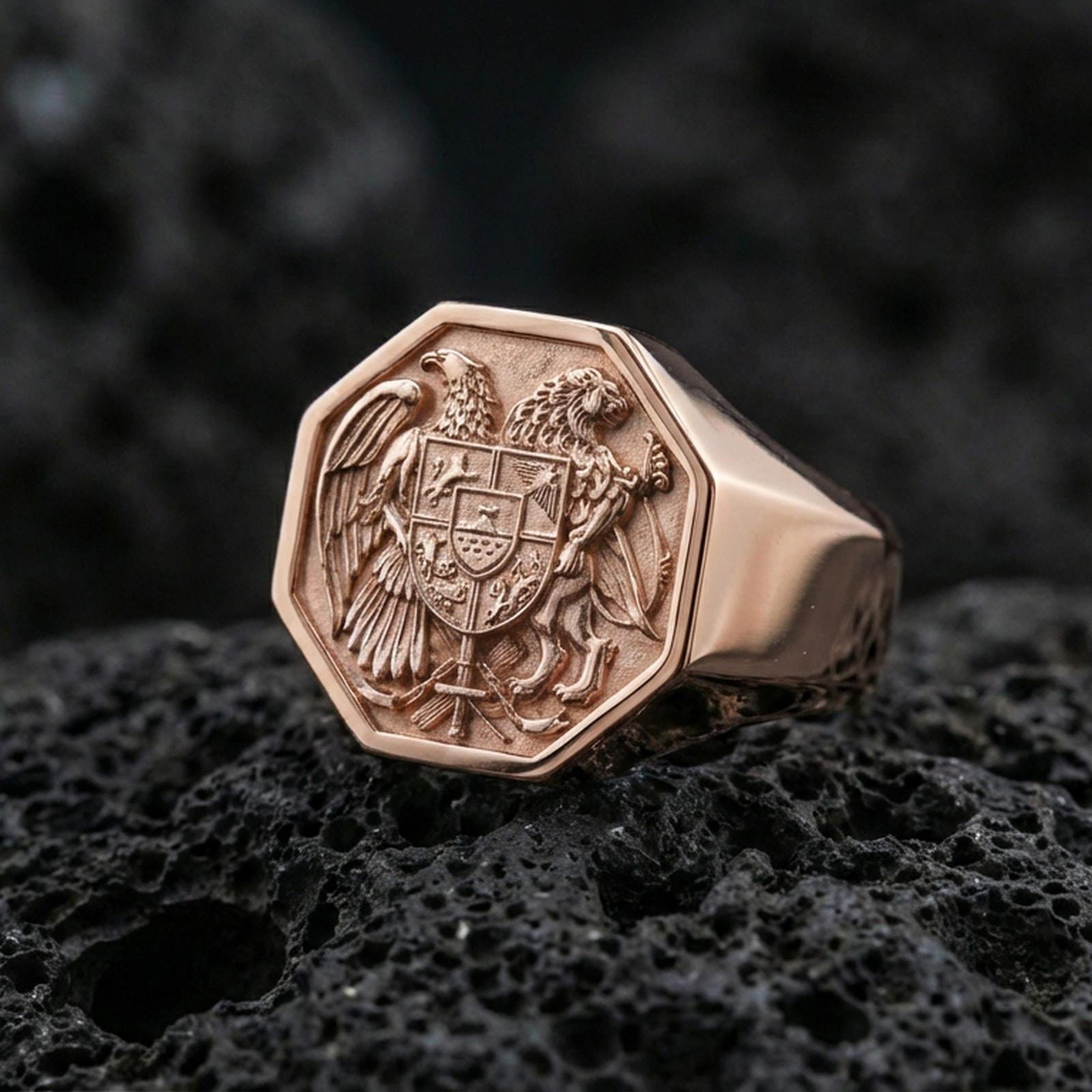 Sterling silver Armenian coat of arms signet ring with a rose gold plated finish, bold heraldic signet ring featuring eagle and lion coat of arms, close-up on volcanic rock