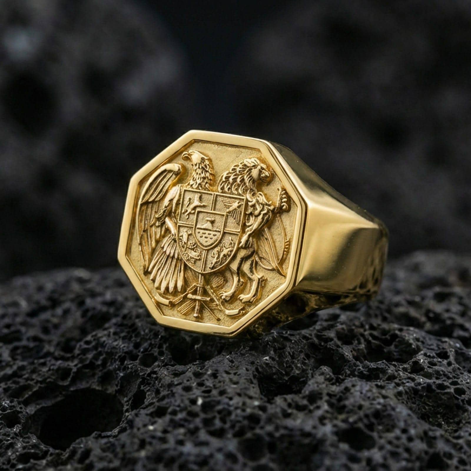 Sterling silver Armenian coat of arms signet ring with a gold plated finish, octagon signet design with Armenian heraldic crest and intricate engraved details, macro on volcanic rock