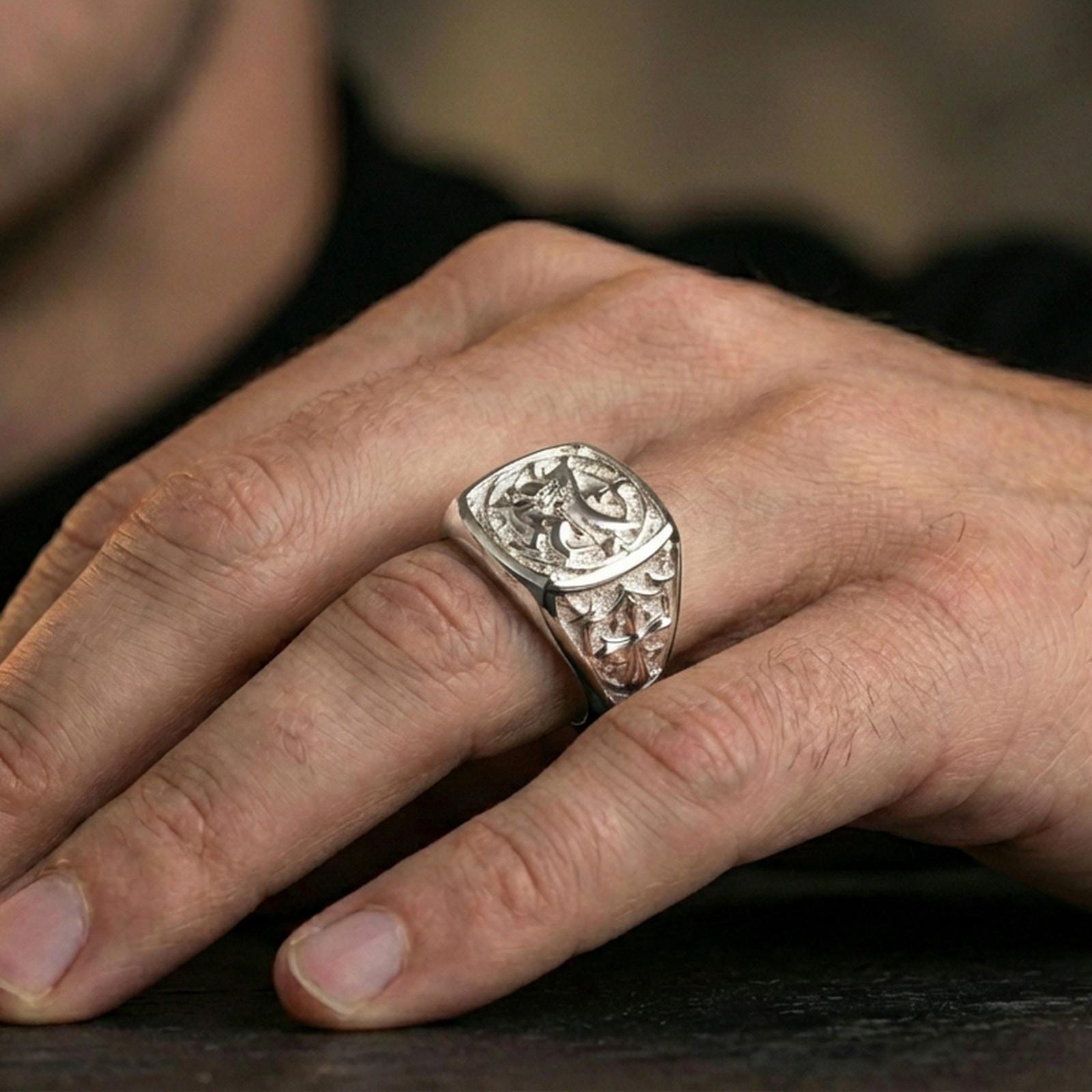 Sterling silver heraldic lion statement ring on a finger, macro lifestyle image emphasizing the polished silver finish and engraved crusader-style side details