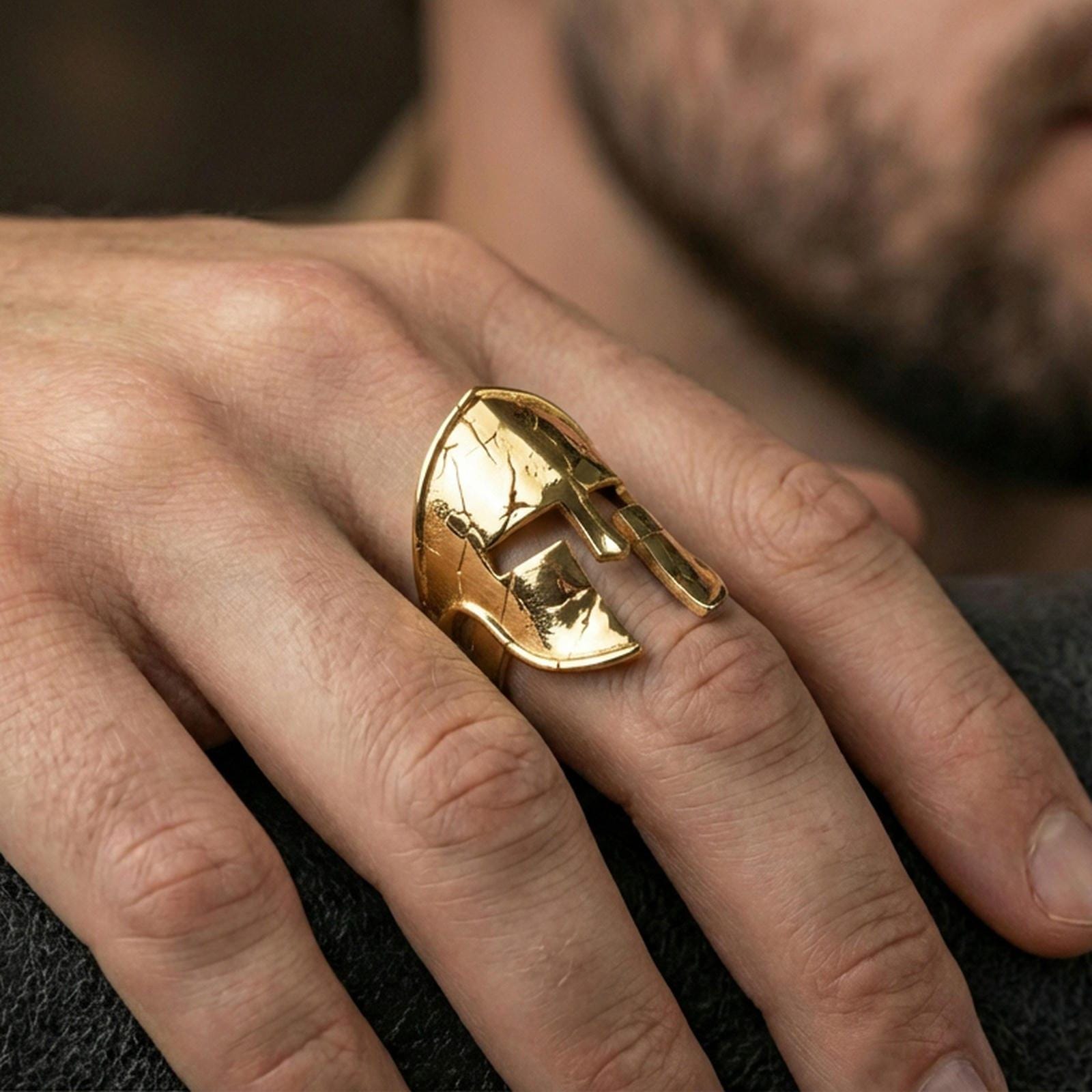 Sterling silver ancient Greek helmet ring worn on a finger, close-up lifestyle photo showcasing the gold plated finish and bold Spartan warrior motif