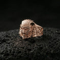 Load image into Gallery viewer, Sterling silver ancient Egypt horror mask ring with a rose gold plated finish, bold mummy pharaoh face and textured headdress lines, close-up on black volcanic rock
