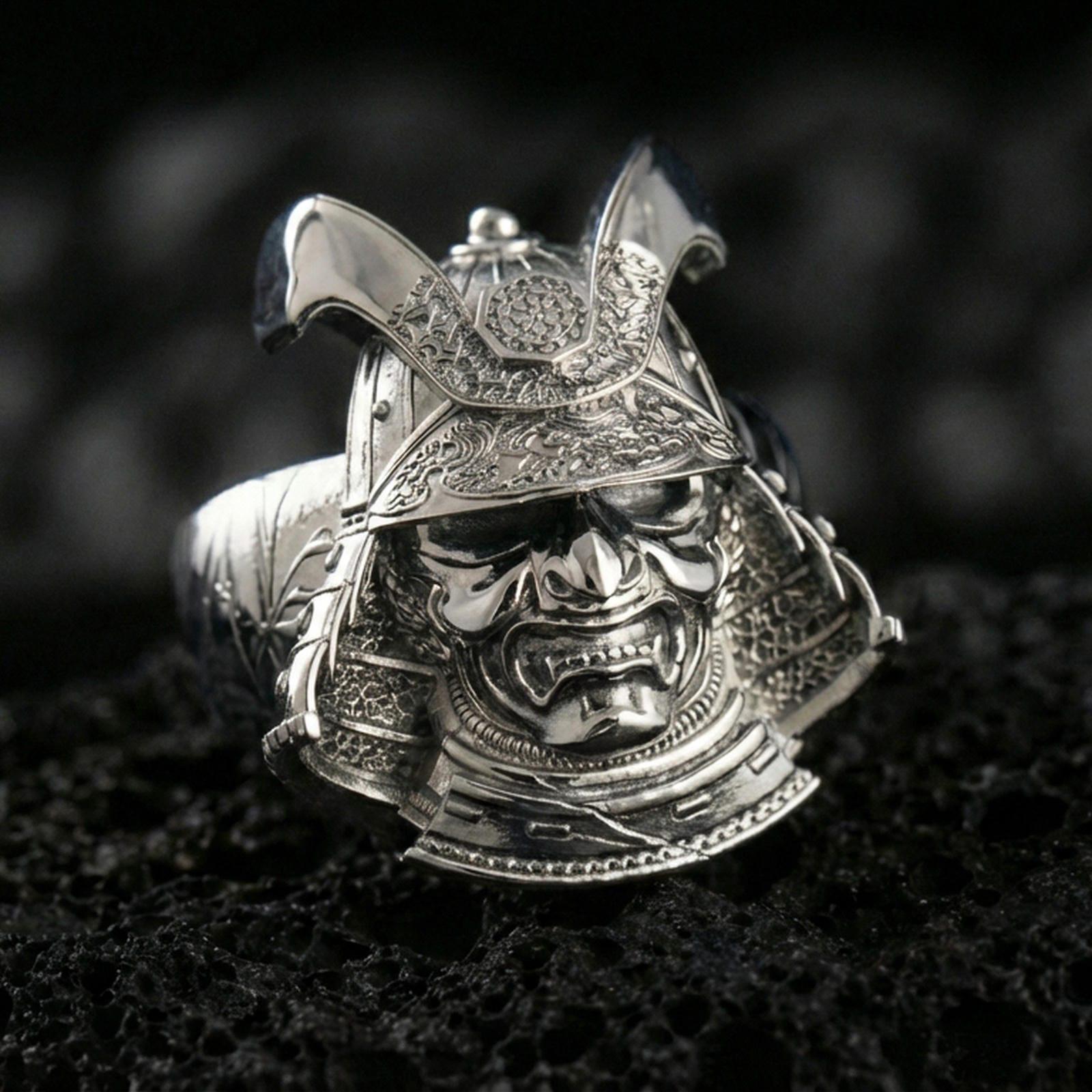 Sterling silver Japanese warrior helmet statement ring in a polished silver finish, sculpted samurai menpo mask design with ornate armor textures, close-up on volcanic stone