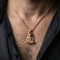 Load image into Gallery viewer, Sterling silver Egyptian ram deity pendant necklace on the neck, macro lifestyle shot showcasing the rose gold plated finish and sculpted meditation figure details
